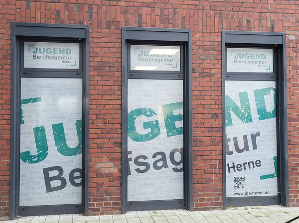 Eine Aufnahme des Haupteinganges des jobcenter Herne bzw. der Jugendberufsagentur in der Markgrafenstraße in Herne. Die Aufnahme wurde vom Fußgängerweg aus angefertigt.